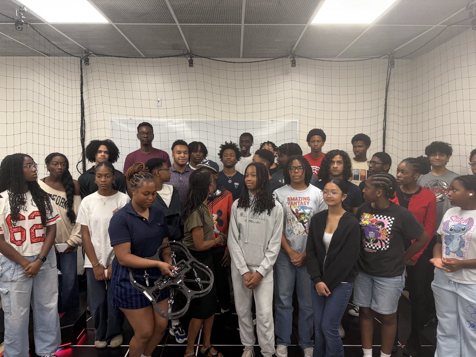 A larger group gathers for a photograph inside the netted AVRC research studio.