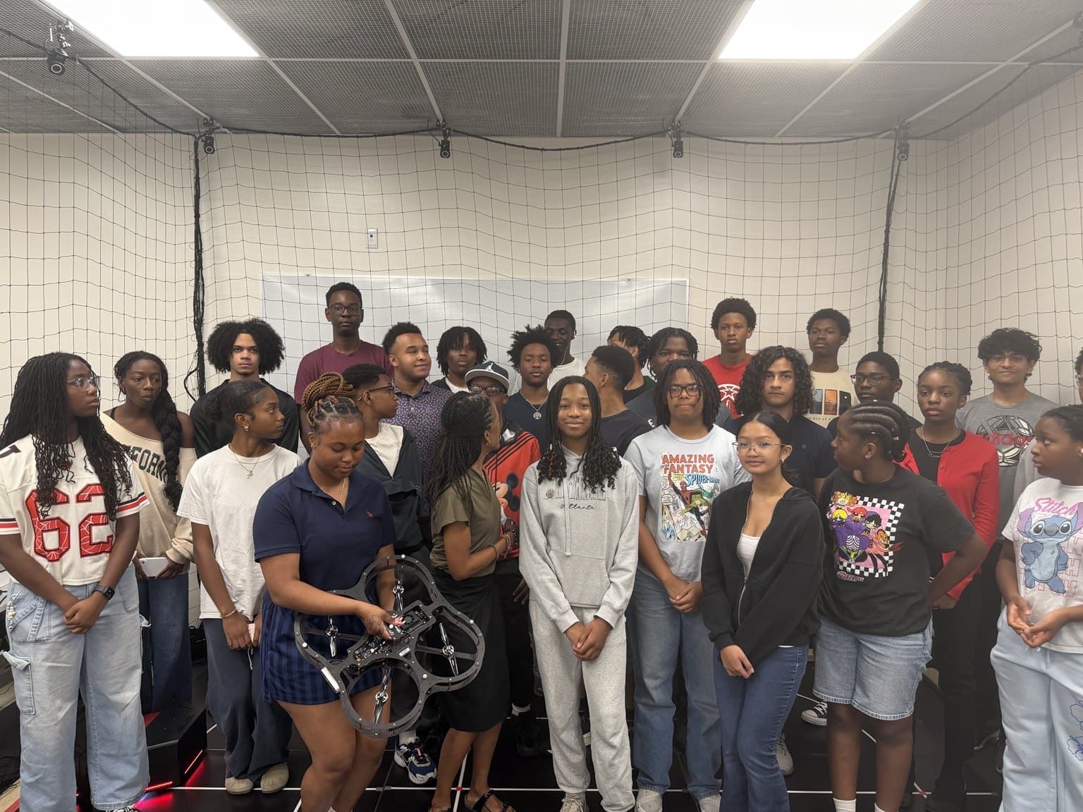 A larger group gathers for a photograph inside the netted AVRC research studio.