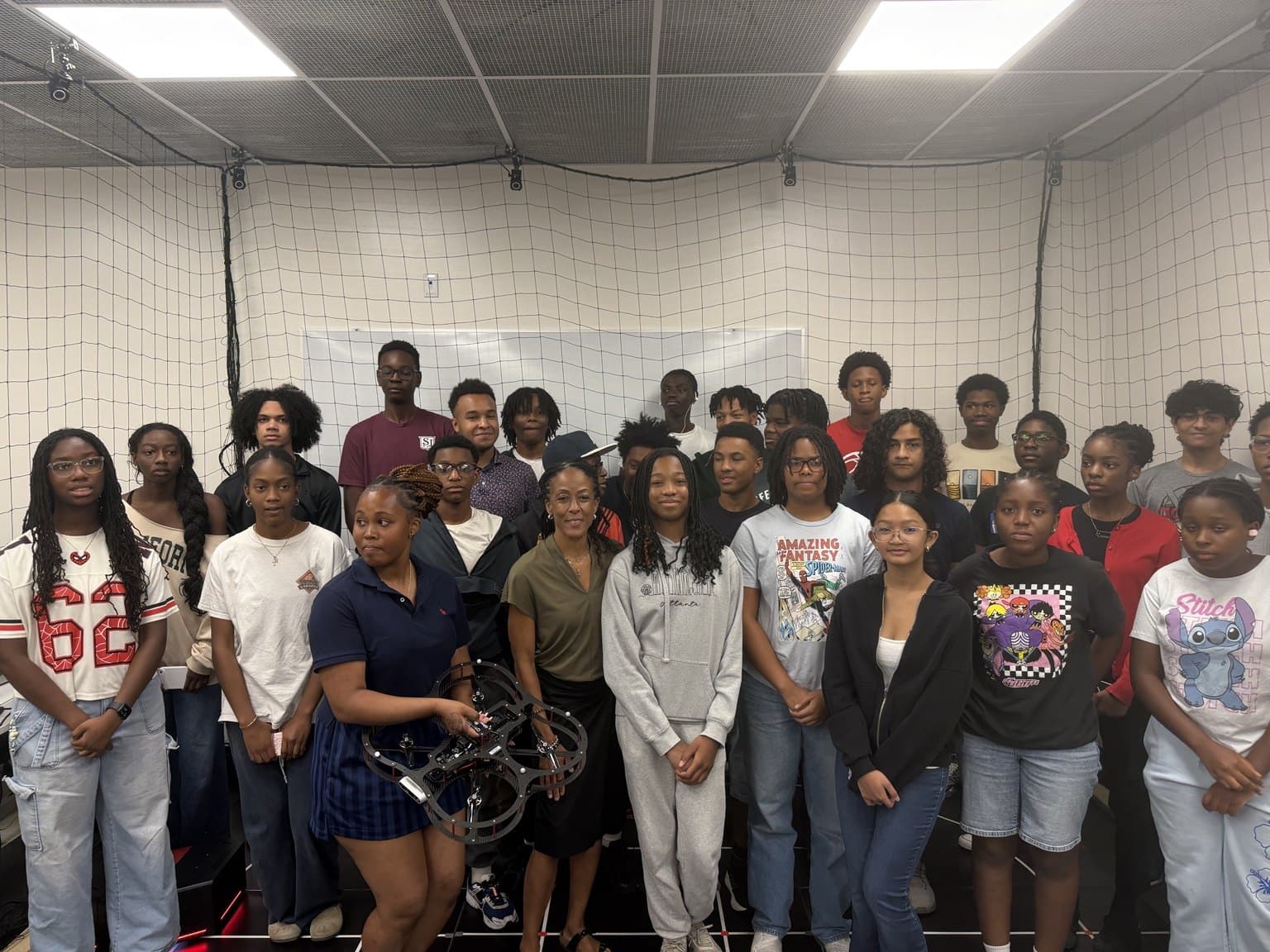 A larger group gathers for a photograph inside the netted AVRC research studio.